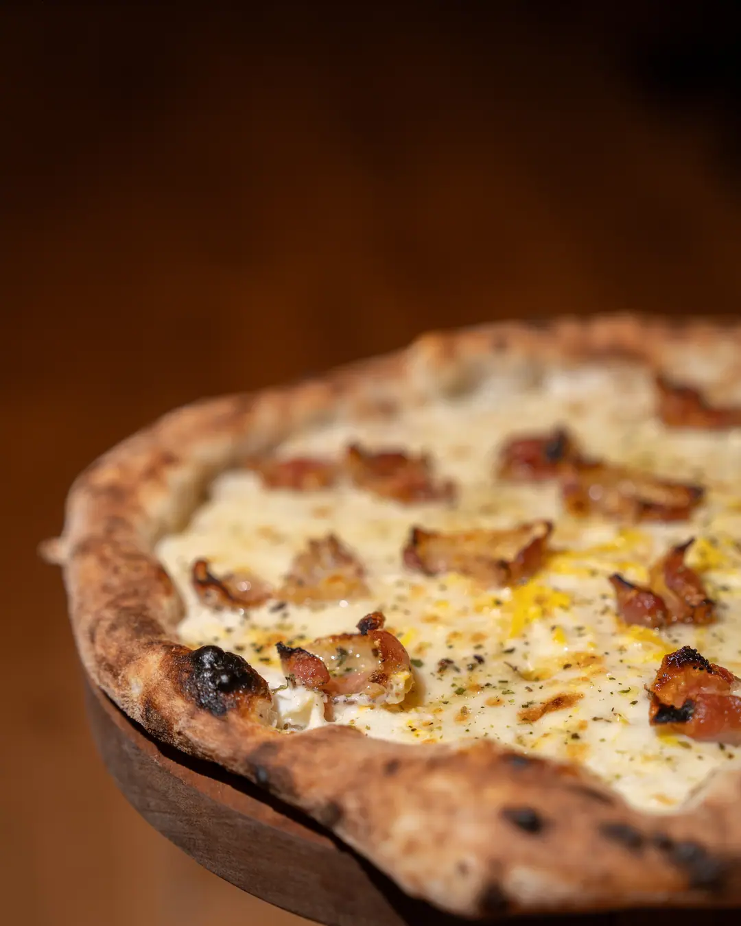 Une Carbonara en gros plan : guanciale, jaune d’œuf et poivre sur la crème