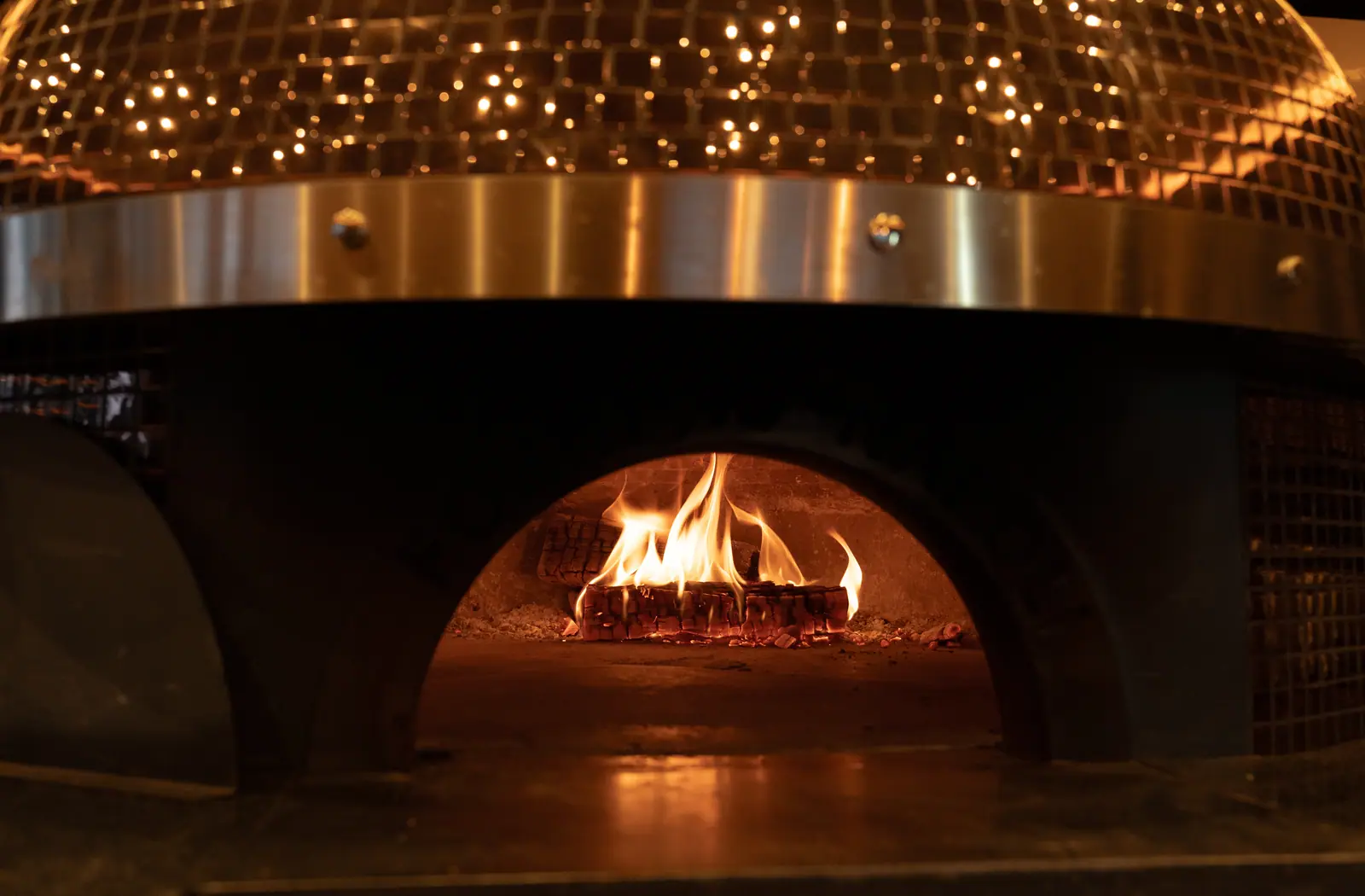 Le dôme du four couvert de mosaïque de cuivre, la flamme au fond de la bouche