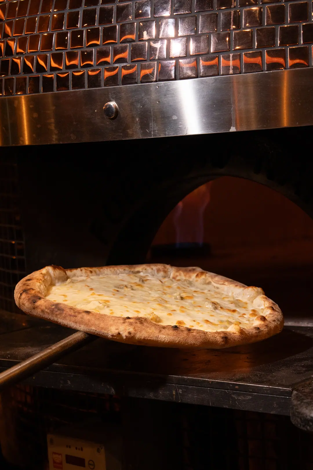 Une pizza sort du four sur la pelle