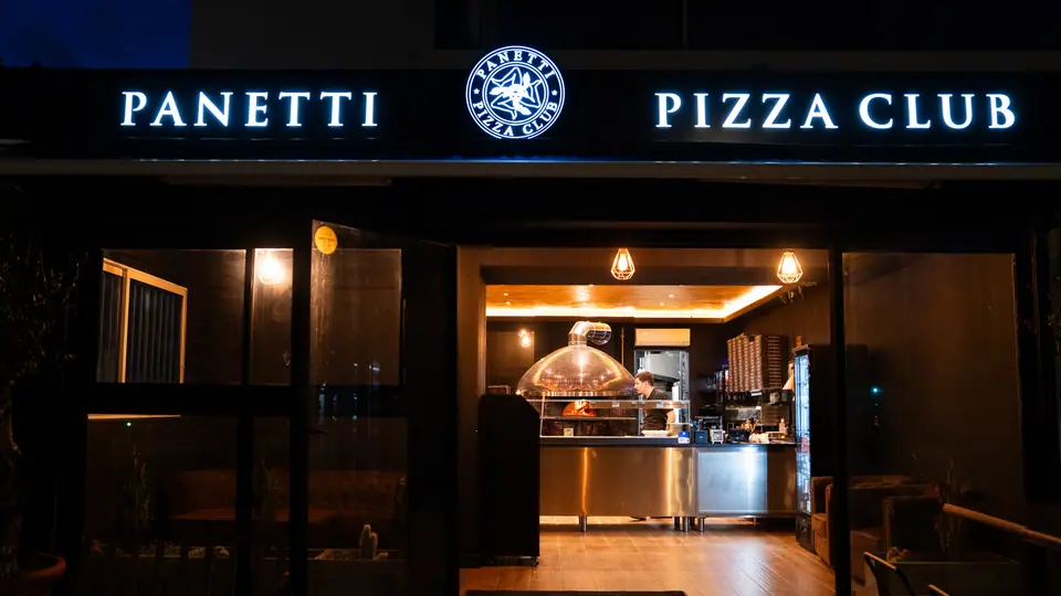 La devanture de Cagnes-sur-Mer éclairée de nuit, l’enseigne Panetti Pizza Club allumée